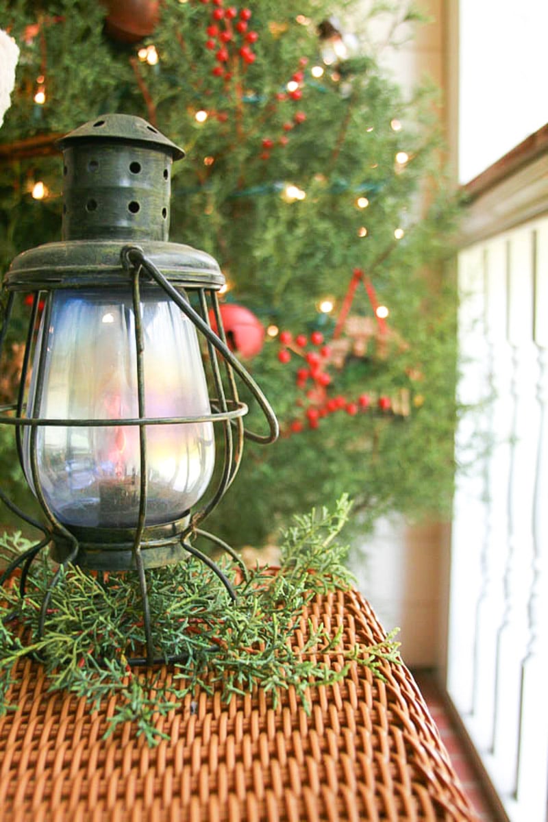 Simple rustic outdoor Christmas lantern with cuttings from a Christmas tree.