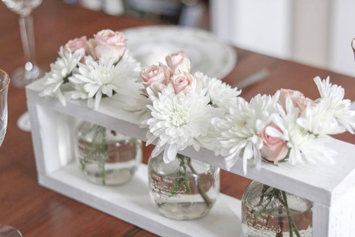 Valentine's table decor idea centerpiece.  Valentine's table decor idea centerpiece.  Valentine's table decor centerpiece.  Valentine's table decorations with china, crystal, heart doilies, farmhouse wooden flower vase holder filled with pink roses and white daisies.