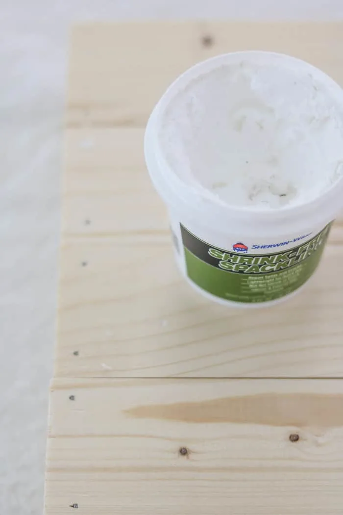 An open container of spackling on a board