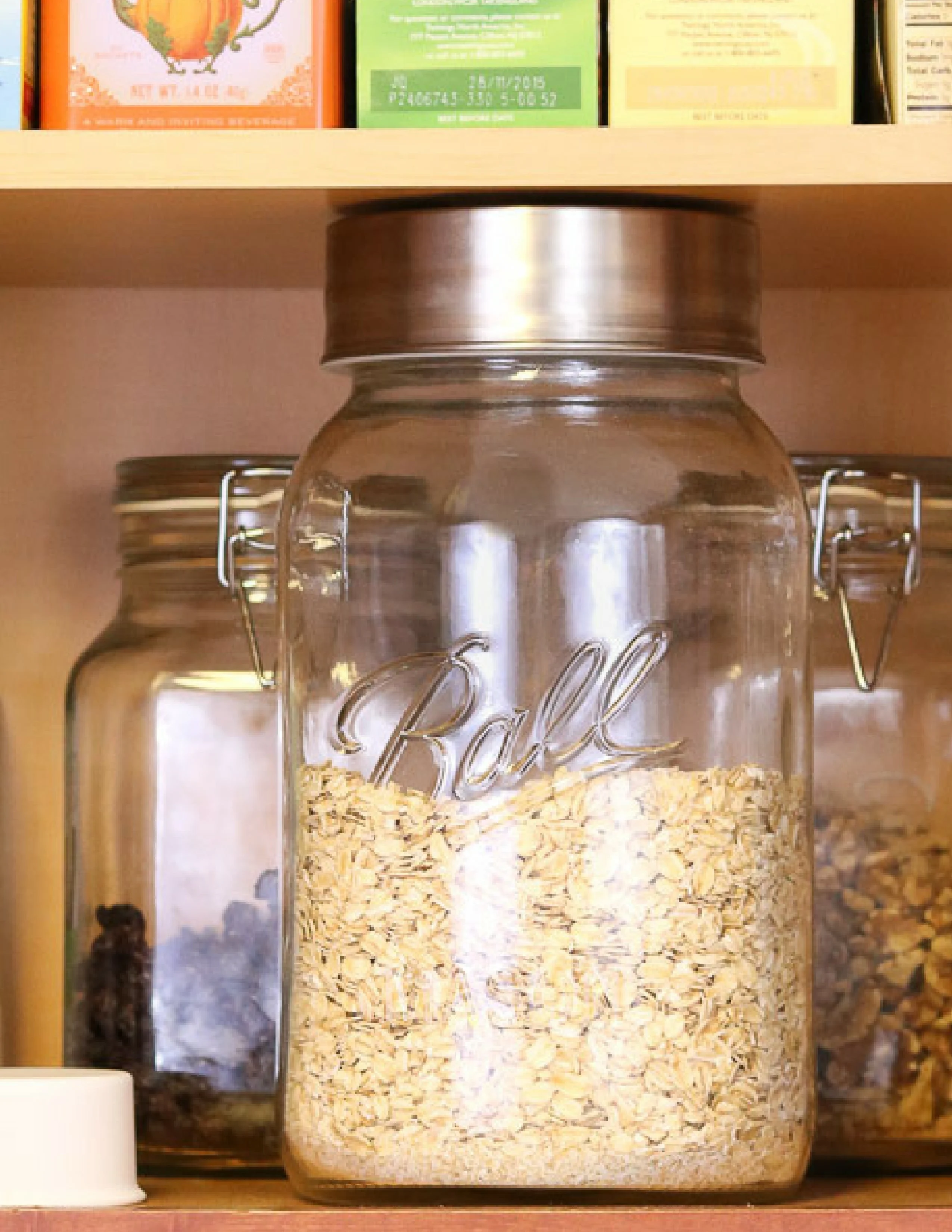 How to organize kitchen cabinets by zones.  A breakfast zone with a mason jar full of oats and other jars with toppings.