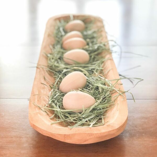 Easy spring decor ideas - wooden dough bowl with timothy hay and wooden eggs