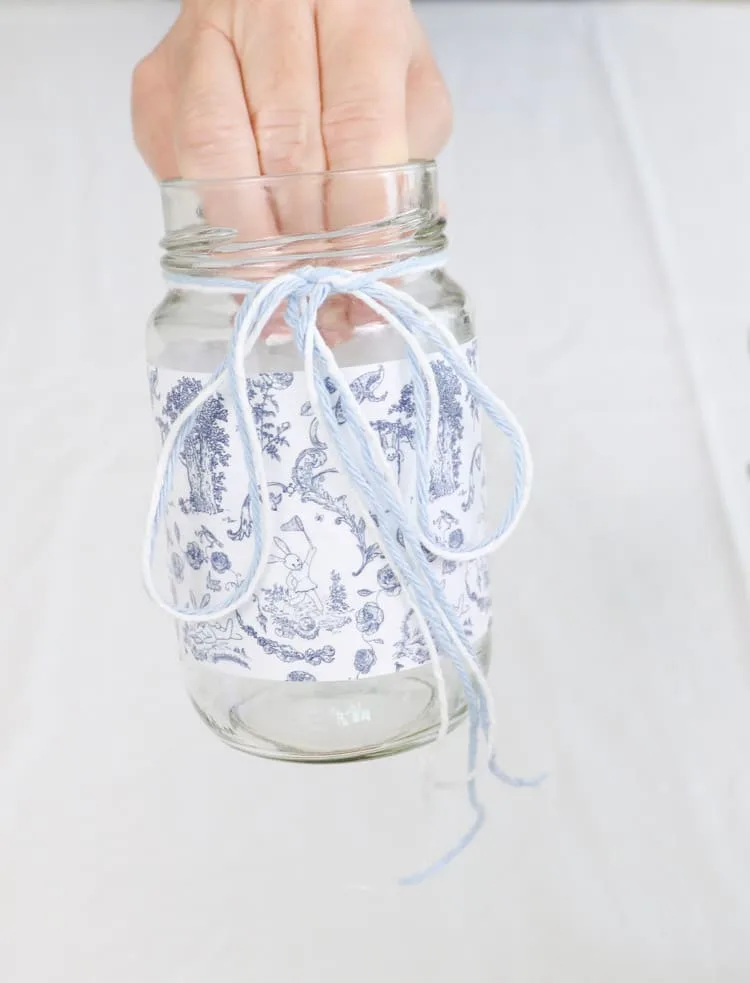 May day basket with a glass jar wrapped in a toile free printable and white twine and blue yarn