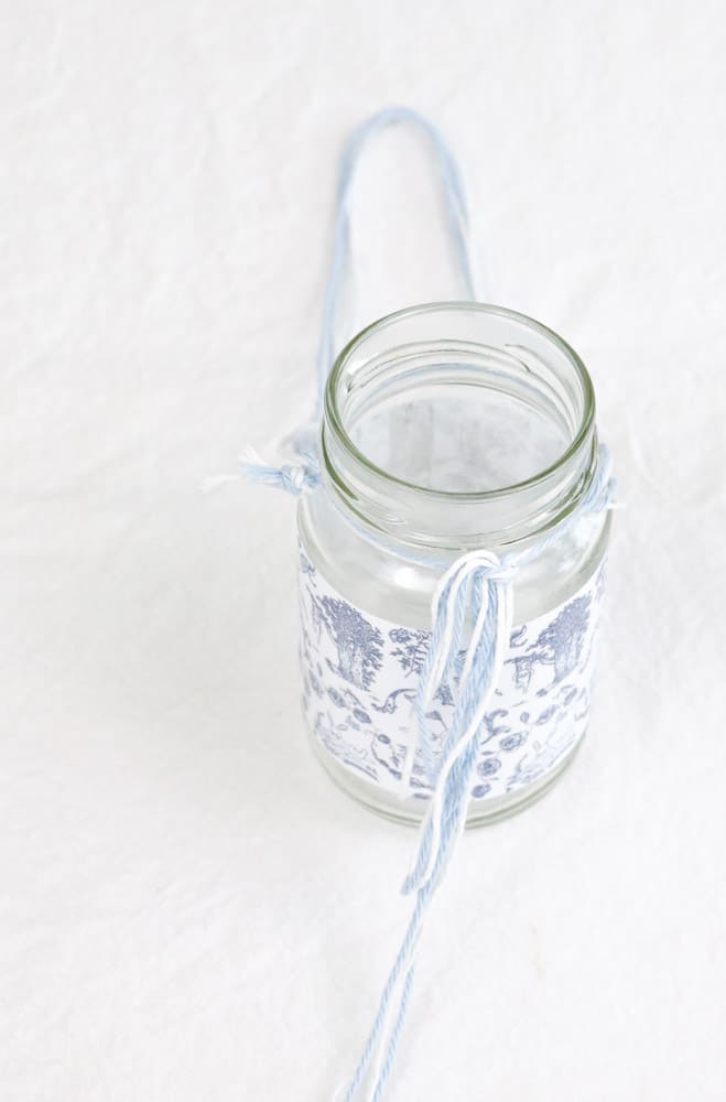 May day basket with a glass jar wrapped in a toile free printable and white twine and blue yarn 
