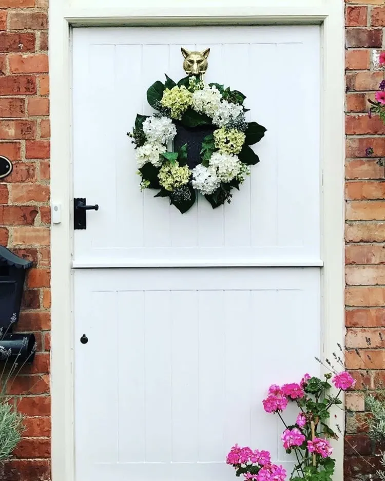 Modern Front Doors by Happy Hound Family with a white from door on a brick home and a white and green hydrangea flower wreath