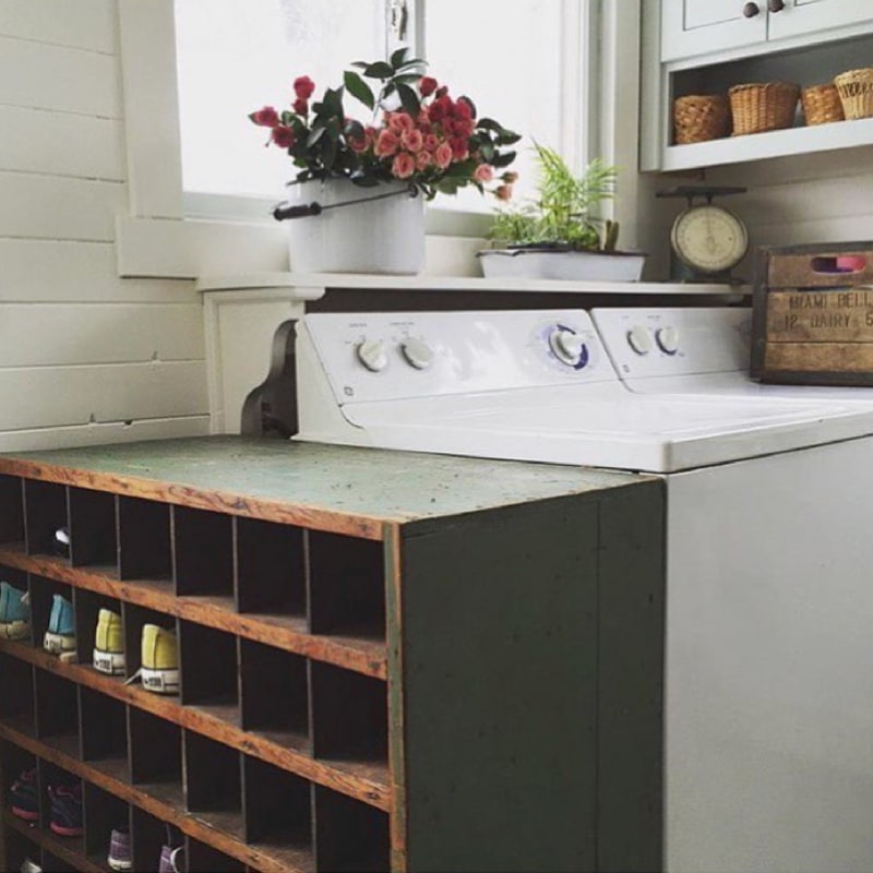 Vintage cabinet with cubbies for shoes in an old farmhouse laundry room by Farmhouse Green