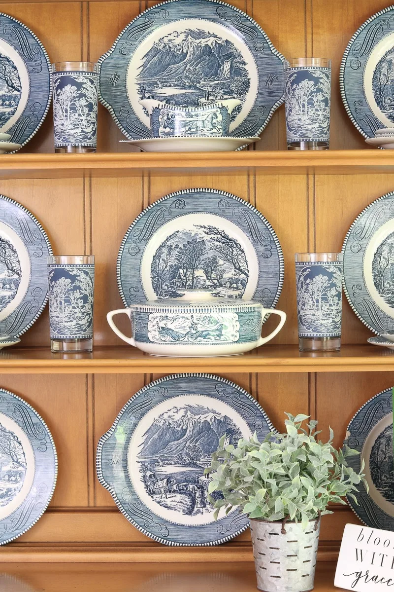 Currier & Ives dishes in a farmhouse hutch