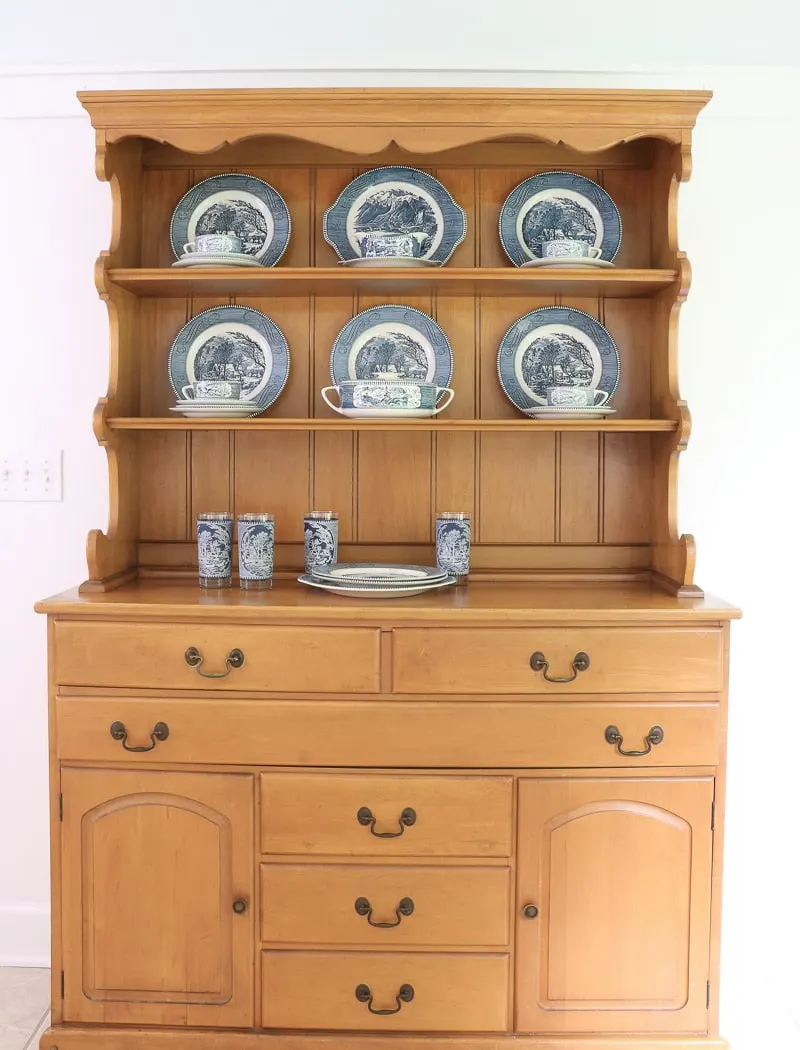 Layer smaller plates, cup and saucers on the sides in this farmhouse hutch