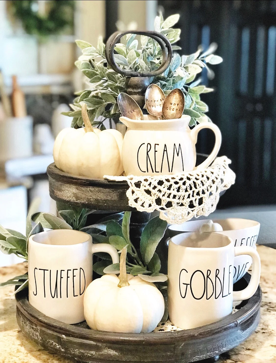 Fall Decor rustic two tiered tray by Farm to Table Creations. This tray idea is packed with rae dunn goodness, plants, white pumpkins and delicate lace. This tray can stay out for Halloween, all autumn and Thanksgiving.