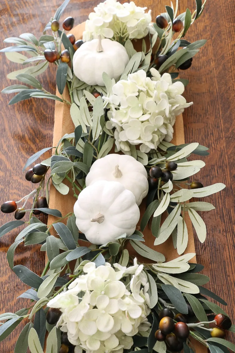 fall floral arrangement using olive branches, white hydrangeas and white pumpkins