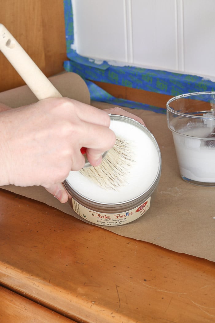 Dipping the waxing brush into the wax and moving in a circular motion.