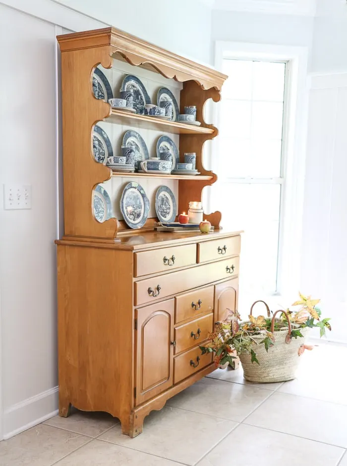 The finished hutch with chalk painted back and Currier and Ives dishes displayed inside.