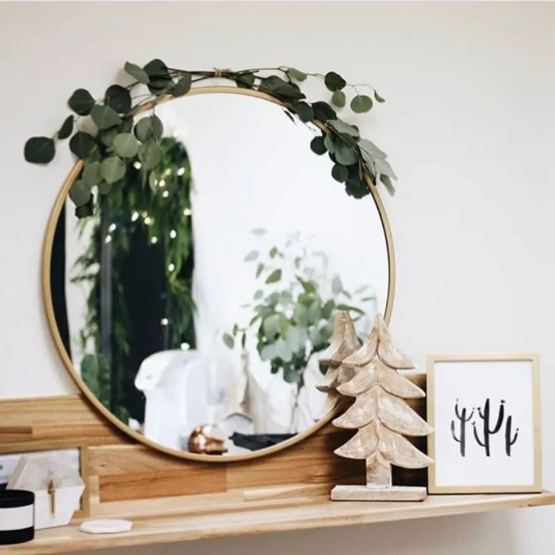 Minimalist Christmas Decorations by Jamie Dana Hairstylist mirror decorated with eucalyptus branches and wooden Christmas tree
