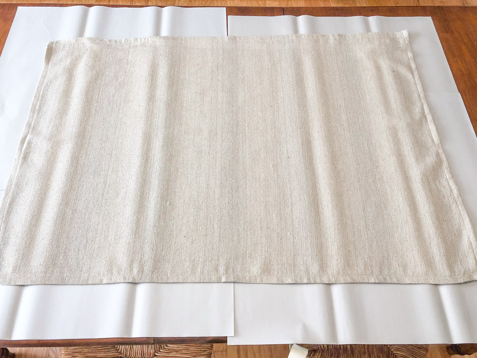DIY rug using a drop cloth and chalk paint and paper to protect surface