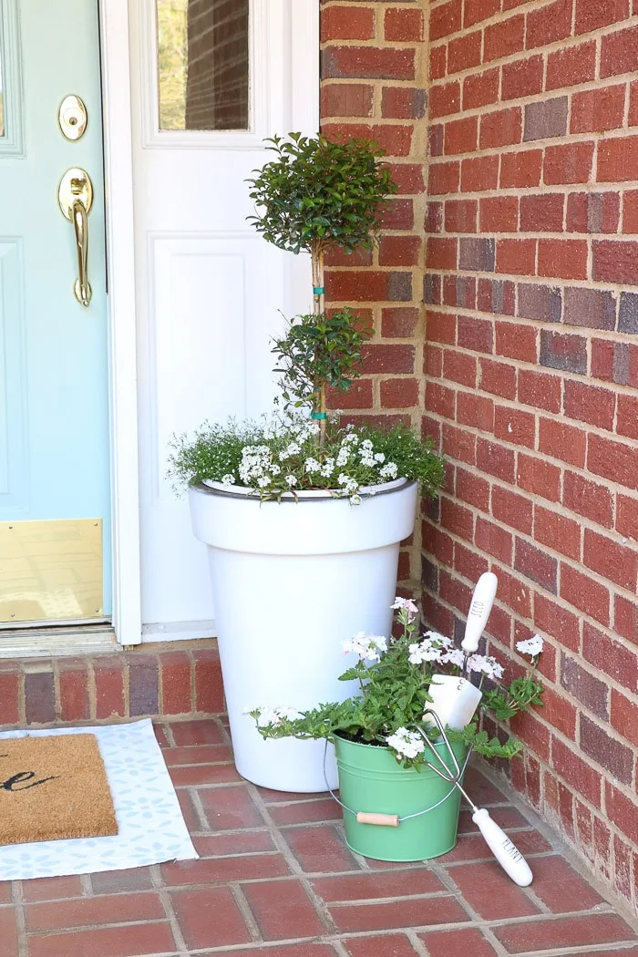 spring porch decorating ideas with plants, flower and pots in a container garden