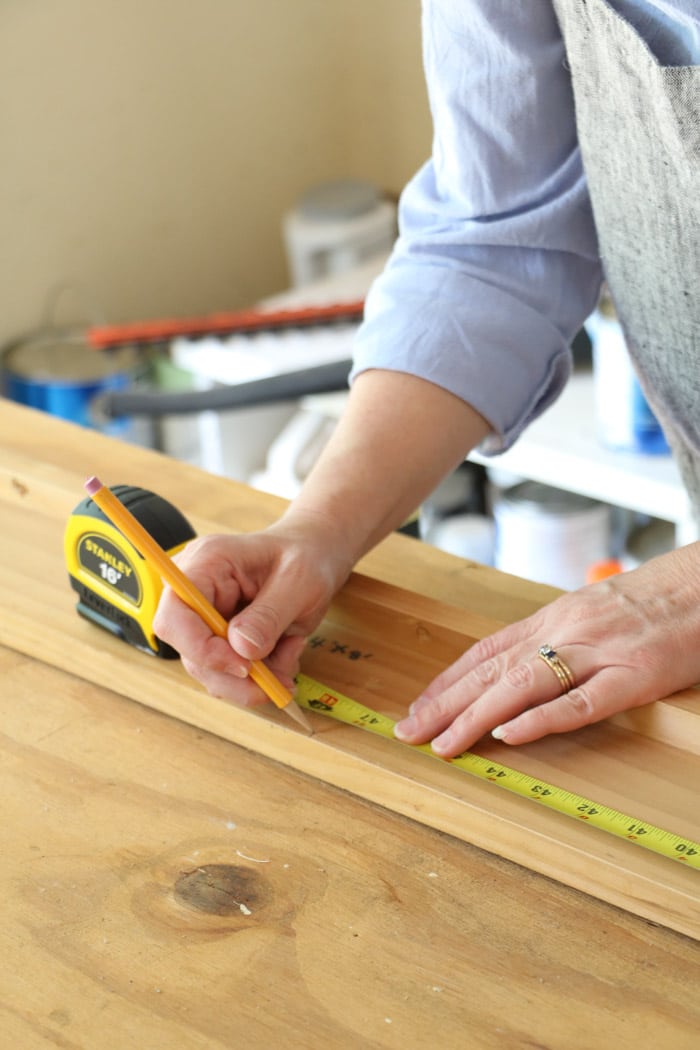 Measuring wood for a DIY coat rack using reclaimed materials