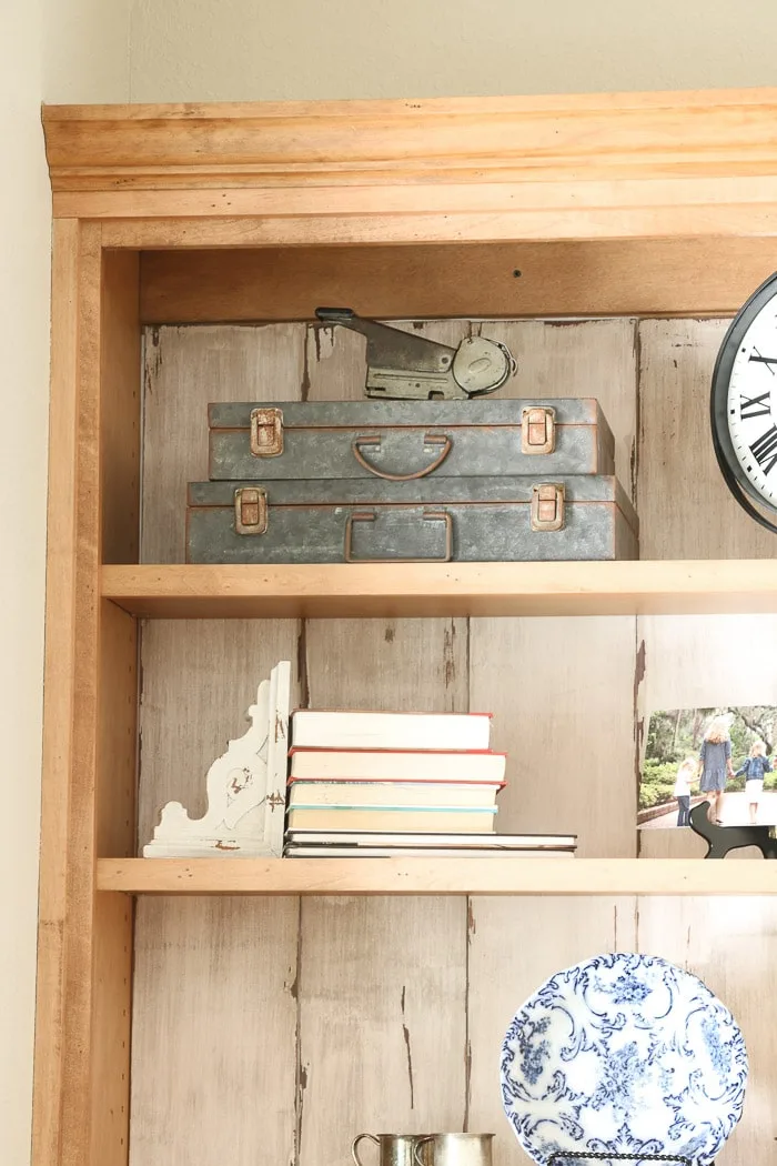 how to decorate a bookcase by adding old vintage boxes