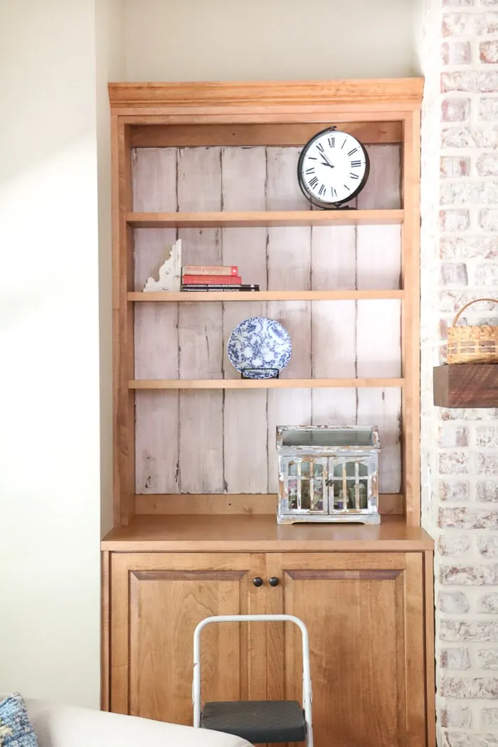 how to decorate a bookcase by adding larger items on each shelf