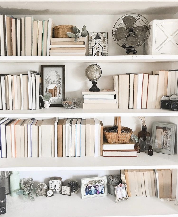 DIY Bookshelf Makeover by Samantha McGlothin with a full bookcase and clocks and vintage fan