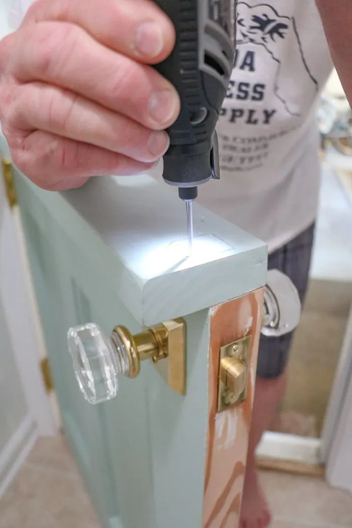 DIY exterior dutch door using Dremel to carve out where hook hole will be placed.