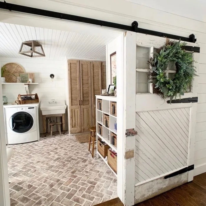 Farmhouse Laundry Room Decor by Love Homemade Home with a sliding farm door and brick flooring