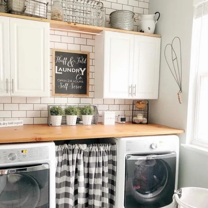 Farmhouse Laundry Room Decor by Gnarled Knot with fluff and fold laundry signs and cabinets
