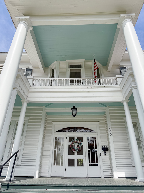 View of white colonial revivial houe with blue porch ceiling