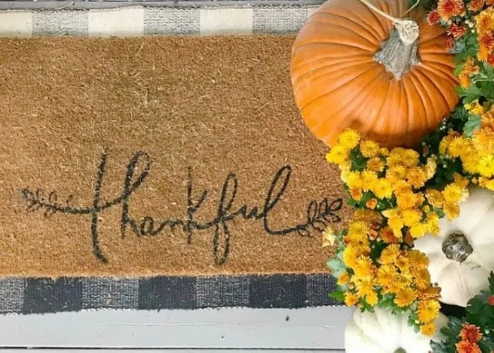 Layered Rug Ideas by The Painted Piano with a thankful fall doormat over a black and white buffalo check rug