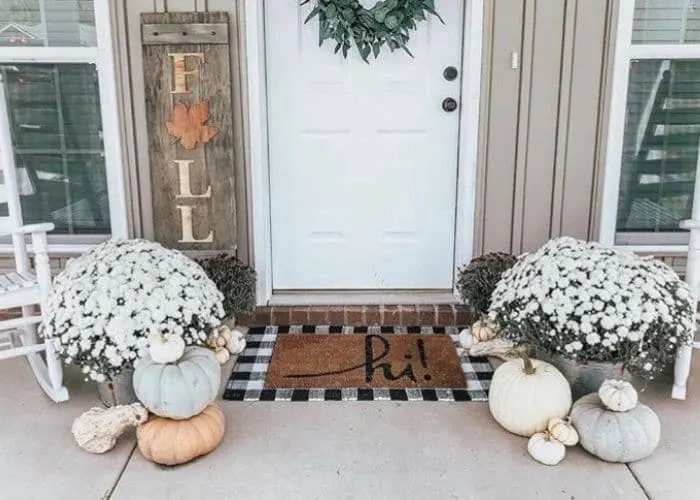 Layered Rug Ideas by Kristen Fortier with a doormat that says hi laying on top of a black and white gingham rug.