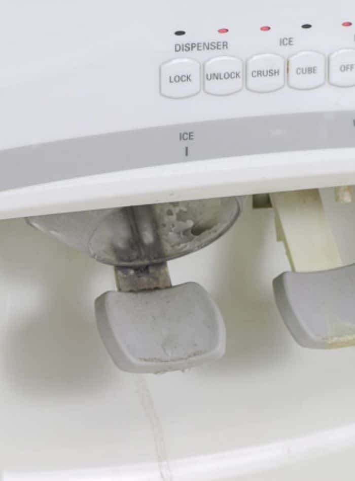 Clean fridge water dispenser by removing parts that are removable and washing them in the sink.