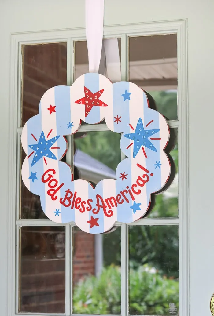 red, white and blue decorations on a small front porch for the July 4th.