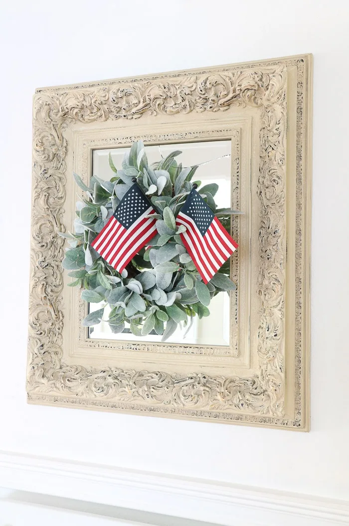 red, white and blue decorations in the entryway with American stick flags in a lambs ear wreath