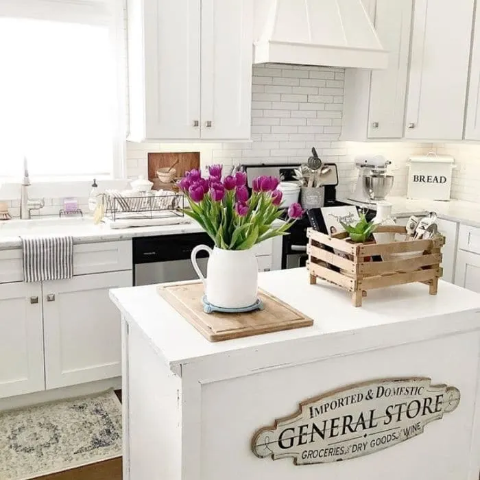 Farmhouse Kitchen with a sign on the kitchen island by French Coastal Home