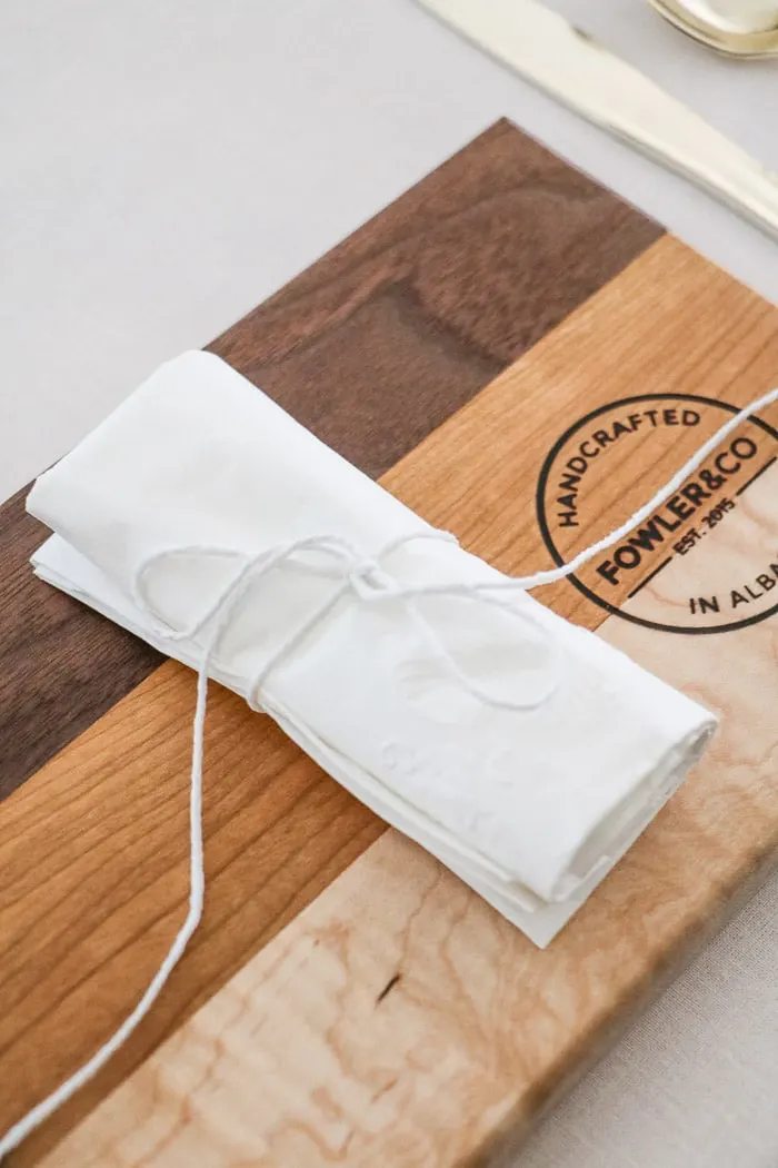 Nurses graduation party ideas.  Place cutting boards at each place setting as plates and top with a rolled napkin that is secured with white twine with long tails