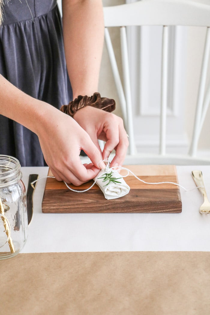 Nurses graduation party ideas.  Place cutting boards at each place setting as plates and top with a rolled napkin that is secured with white twine with long tails.  Then place some rosemary under the twine.