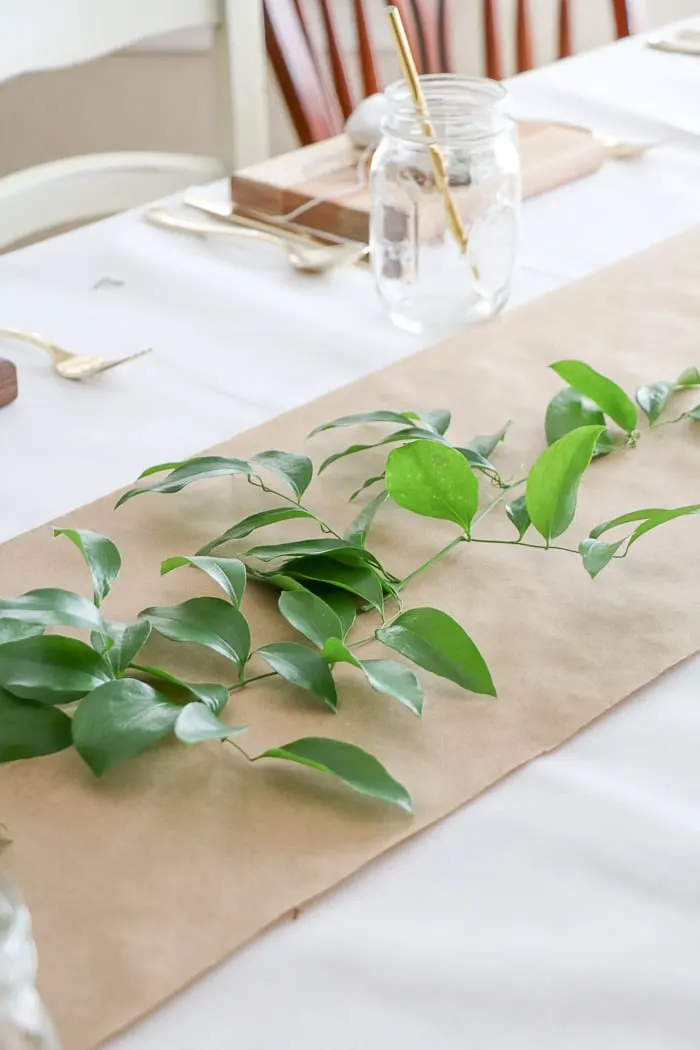 Adding a greenery called smilax that was gathered in the woods along the craft paper runner down the table.  Easy and cheap ideas for nurses graduation party ideas.