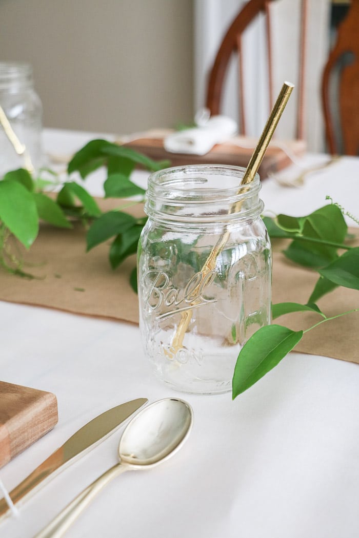 Nurses graduation party ideas placing a Ball mason jar at each place setting along with a gold straw.