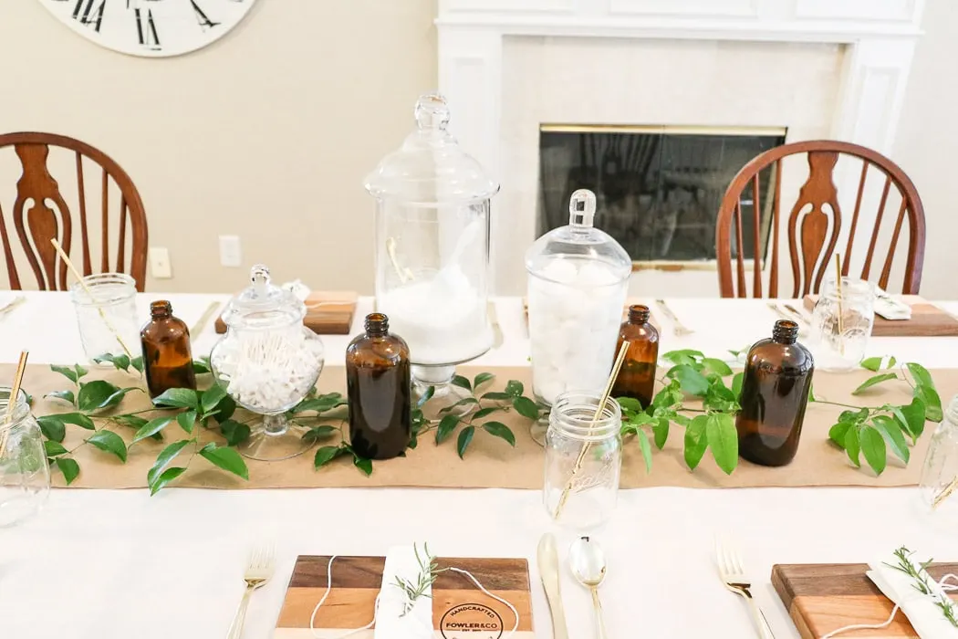 Adding a greenery called smilax that was gathered in the woods along the craft paper runner down the table.  Easy and cheap ideas for nurses graduation party ideas.  And add amber jars to the apothecary centerpiece for a more vintage medicinal vibe.