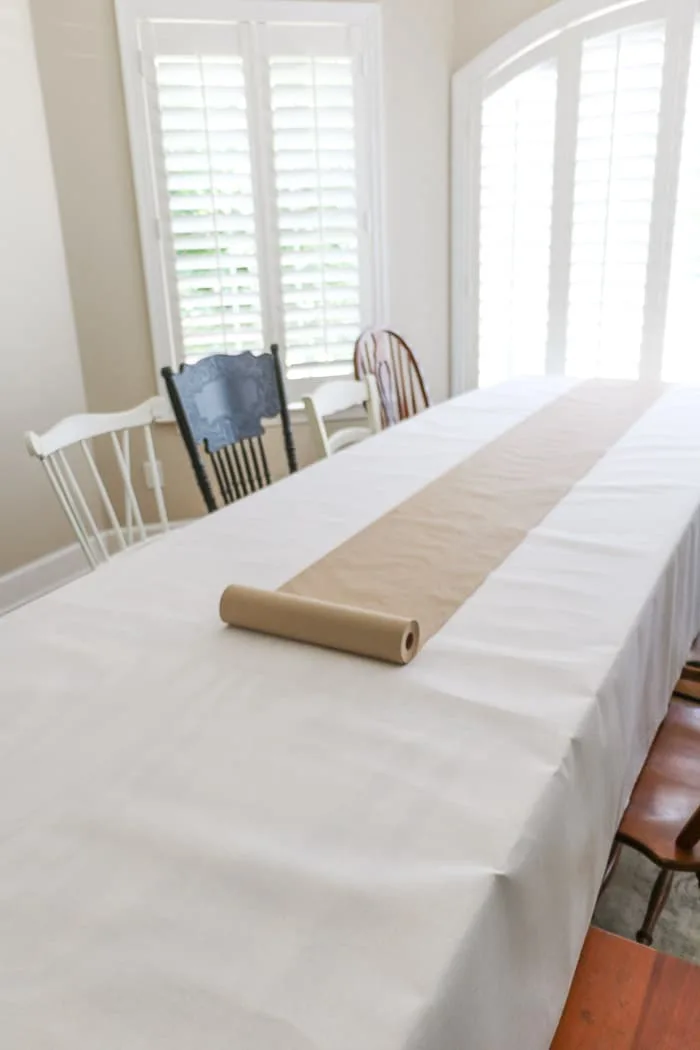 Nurses graduation party ideas using cut by the yard white fabric and brown craft paper for an extra long table.