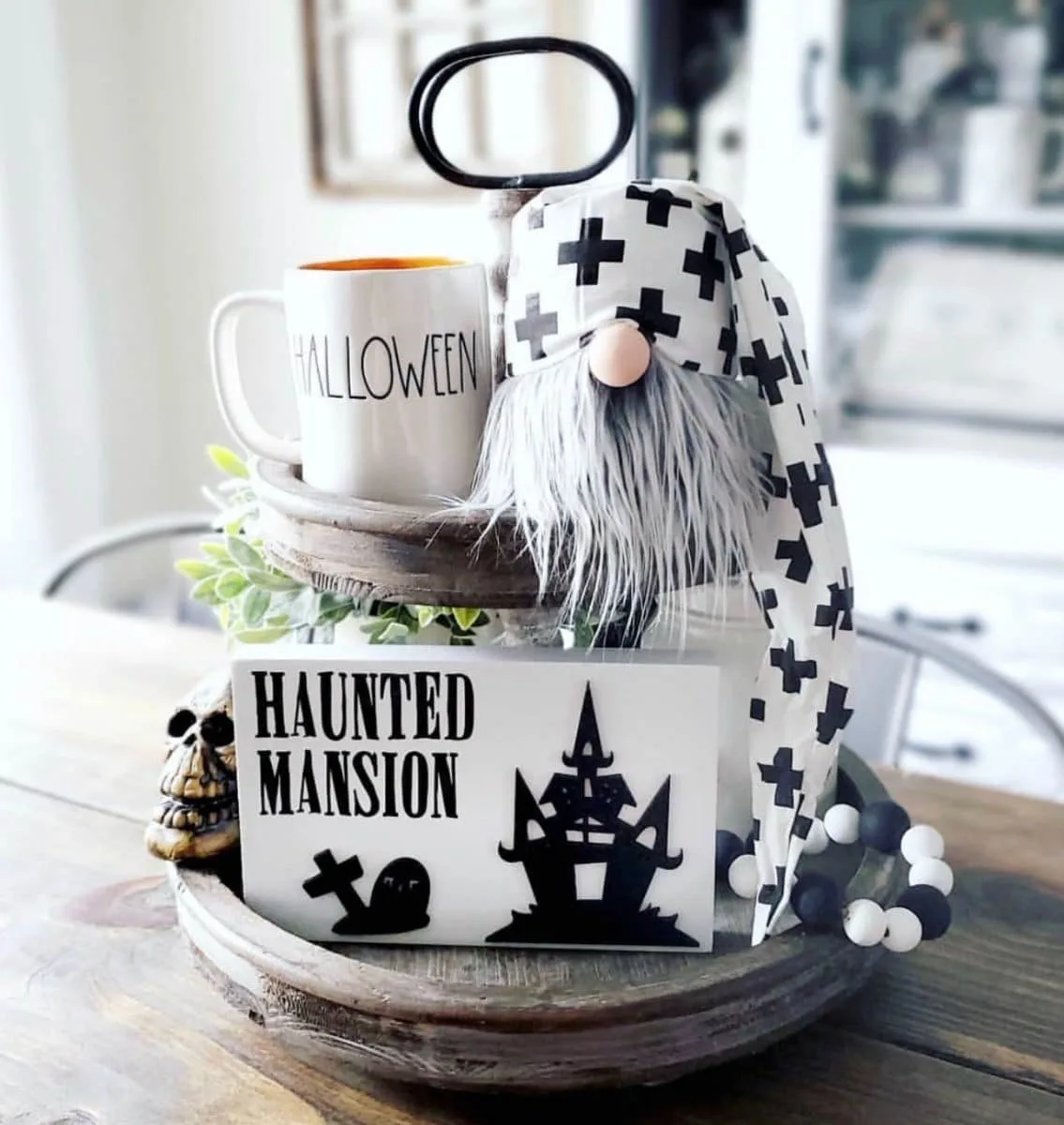 Halloween tiered tray ideas for home.  Gnome, Halloween Rae Dunn mug, haunted mansion sign, black and white wood beads, skeleton