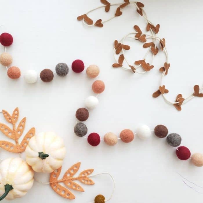 Budget friendly boutique Fall Decor Ideas from jane.com with fall felt garlands of grey, brown, burgundy, orange and white balls.