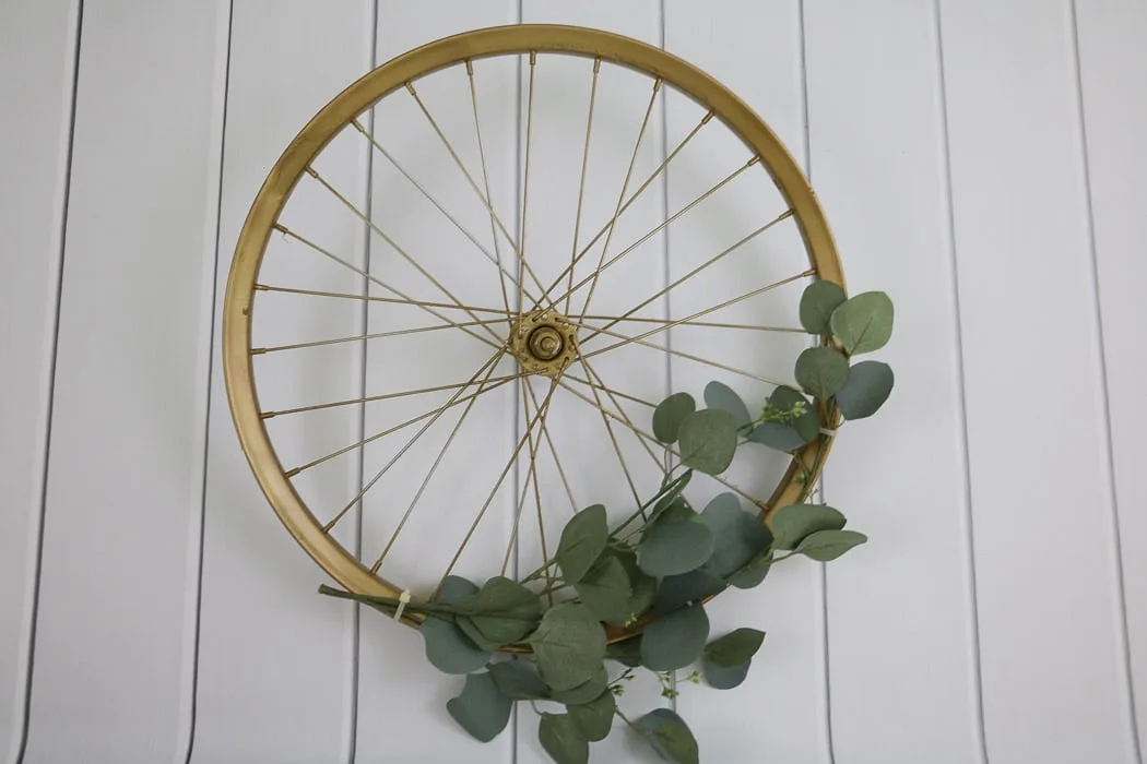 Adding greenery to the bicycle rim after having sprayed it gold