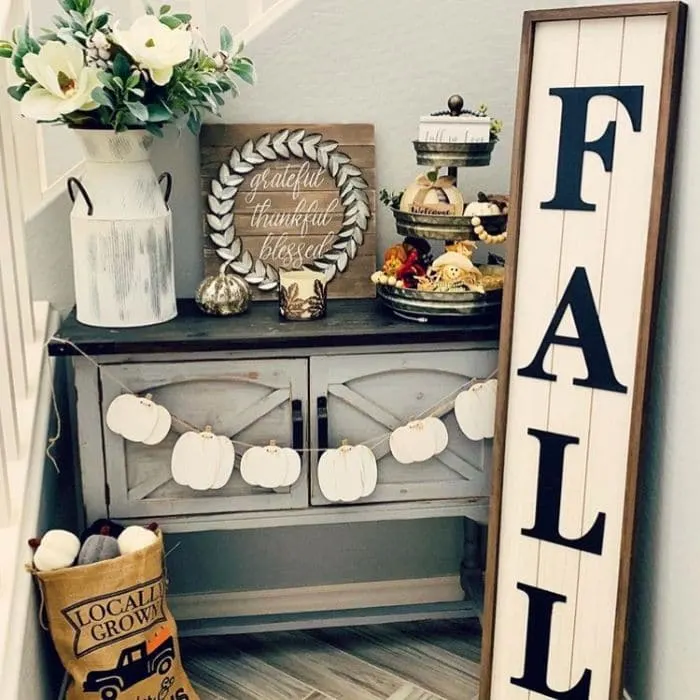 Fall Home Decor by Honeybee Philosophy with a farmhouse fall filled nook, complete with a shiplap fall sign, pumpkin garland and a locally grown burlap pumpkin bag