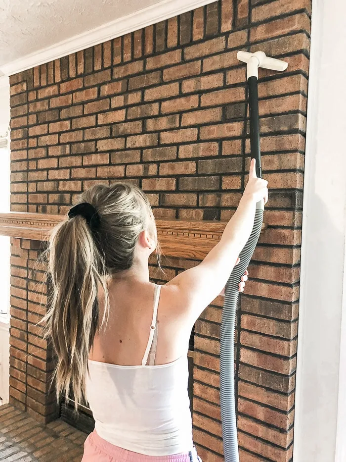 How to paint fireplace bricks beginning with cleaning the bricks with a vacuum.