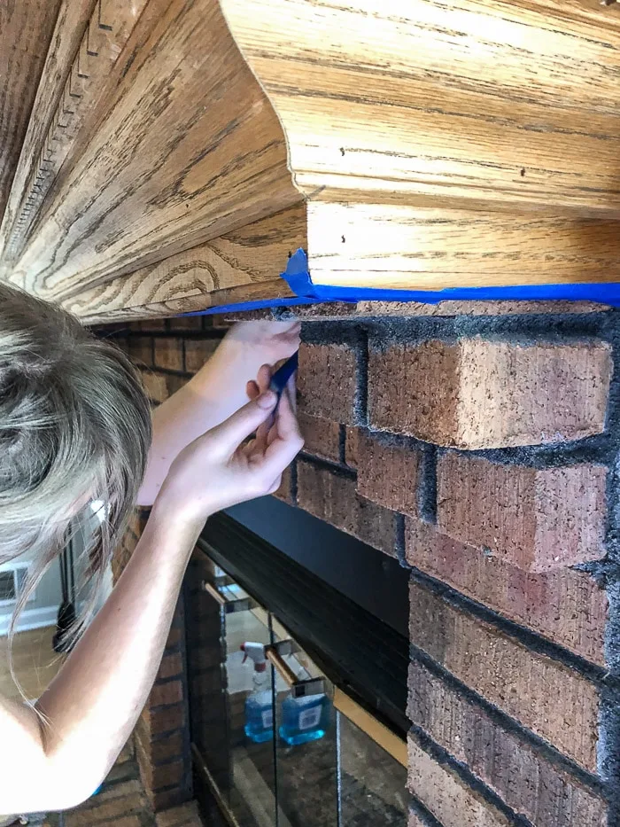 How to paint fireplace bricks.  After cleaning the bricks tape off anything you do not want paint to get on.