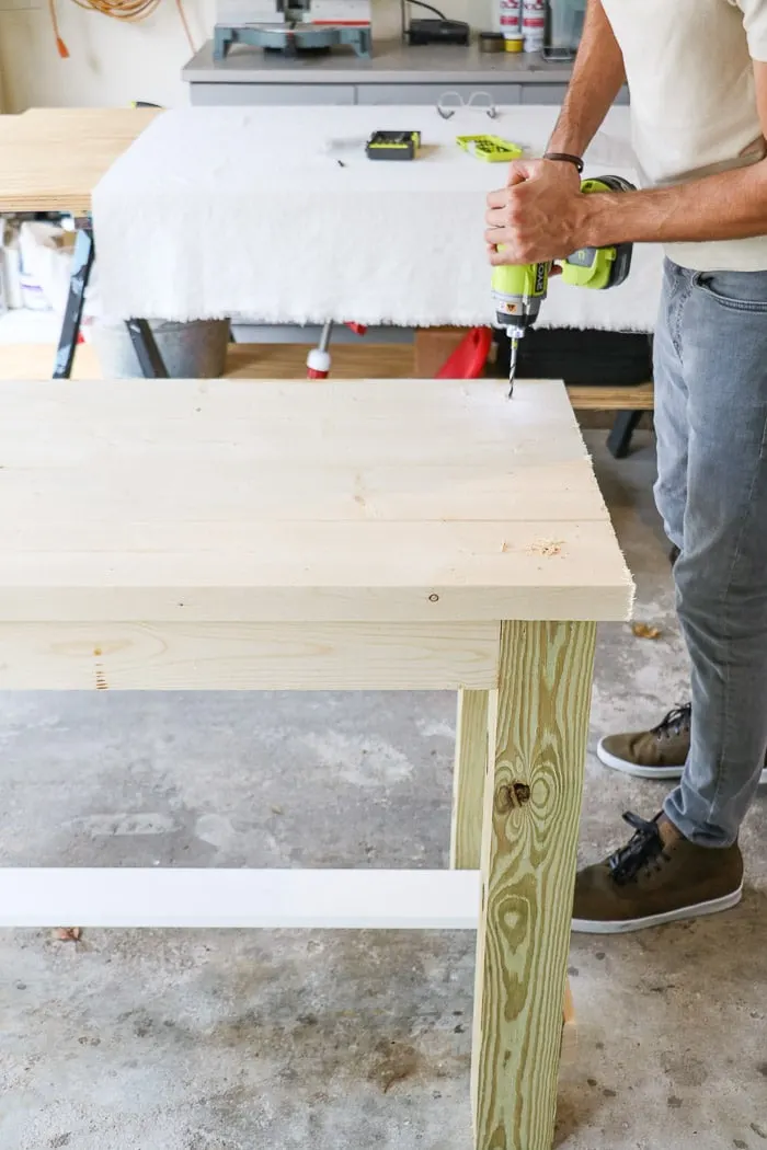 How to build a farmhouse table. Drill hole for screws to go into the legs from the top of the table.