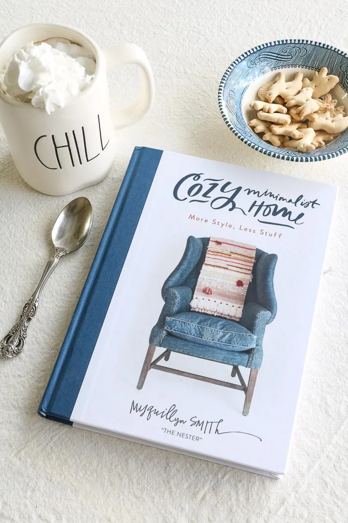 Cozy Minimalist Home by Myquillyn Smith.  One of the best interior design books for beginners.  A warm cup of coffee filled with cream and a bowl of cookies.
