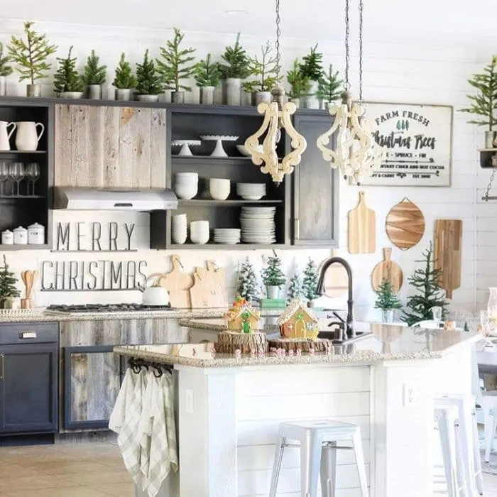 Christmas Kitchen Decor by I Dream of Homemaking with mini Christmas trees on top of cupboards and sprinkled around the countertops