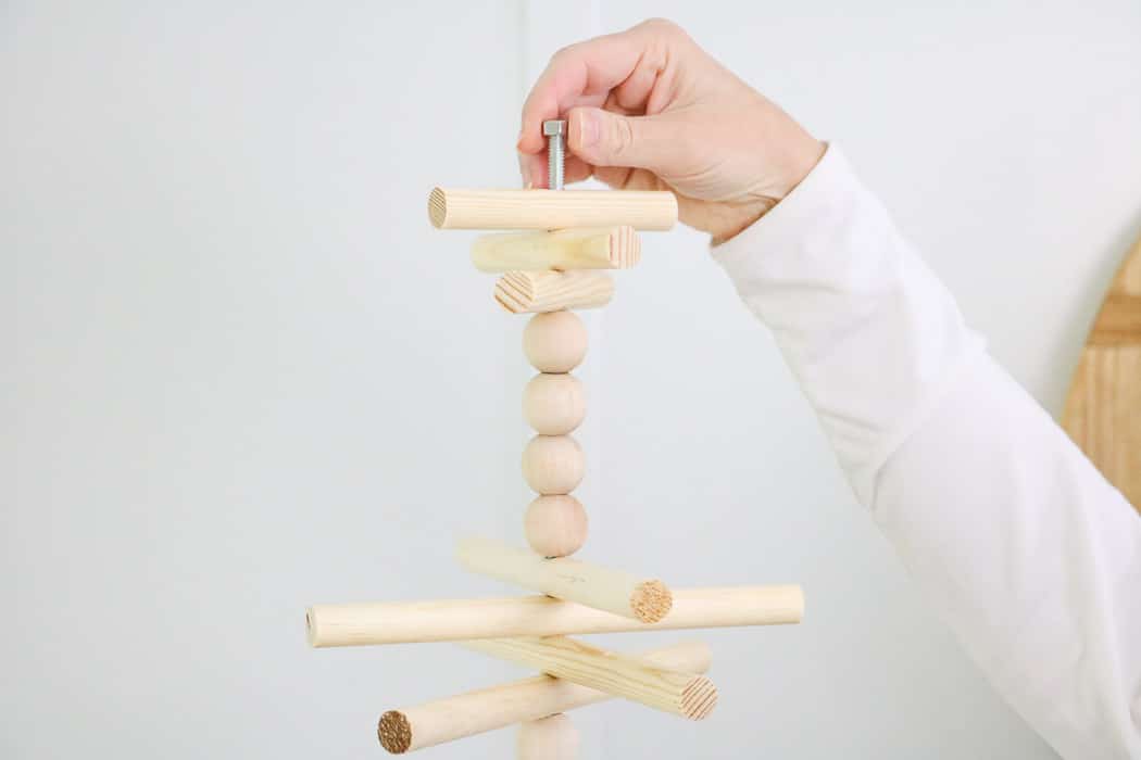 Wooden dowel Christmas tree designed for the kitchen with gingerbread ornaments. Add a hex nut to the top