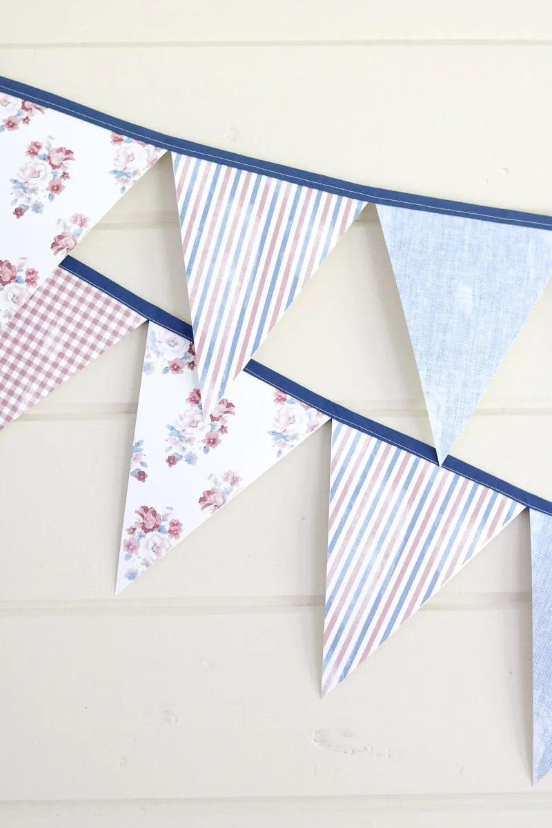 Free printable banner in distressed fabric patterns of chambray, red and white stripes, floral pattern and red and white gingham.