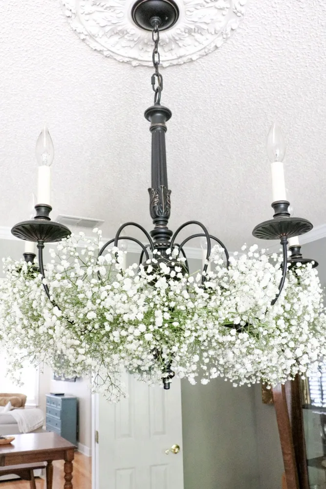 Decorate a chandelier with baby's breath flowers.